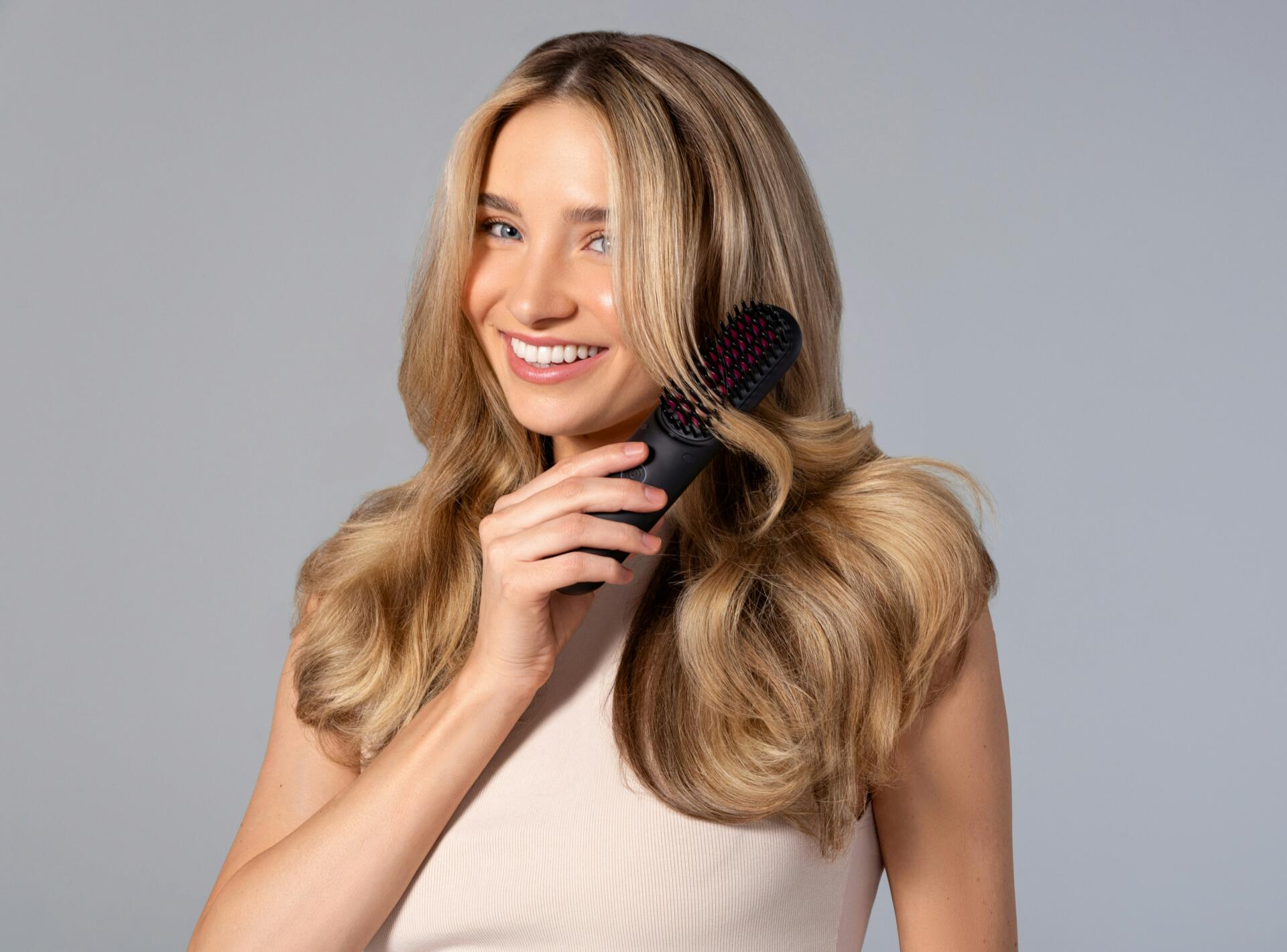 Young woman with blonde hair brushing her hair