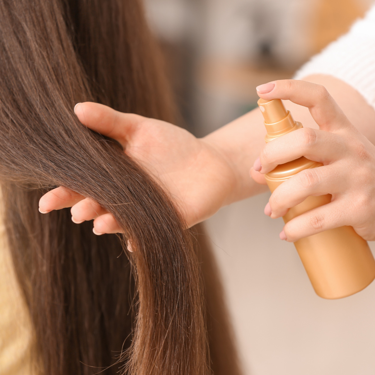 Stylist spraying hair treatment onto damaged hair