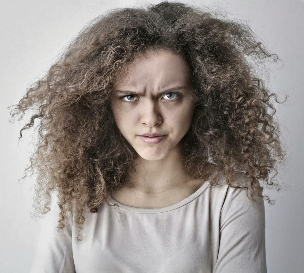 Young woman struggling with frizzy hair