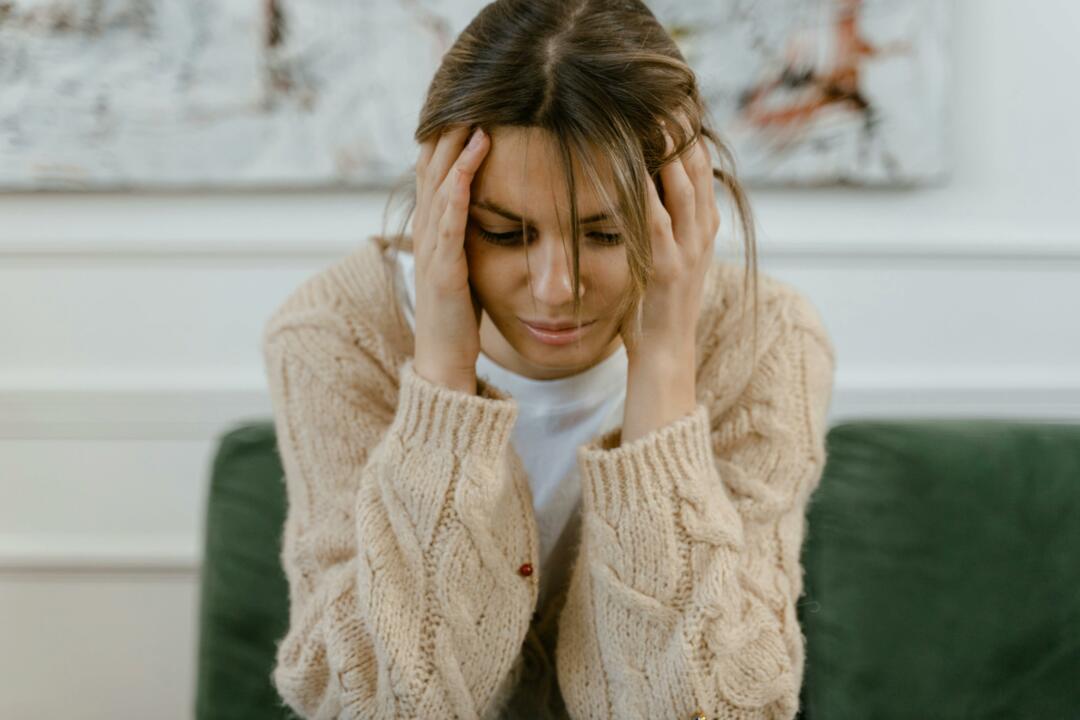 Woman struggling with dry hair, head in her hands