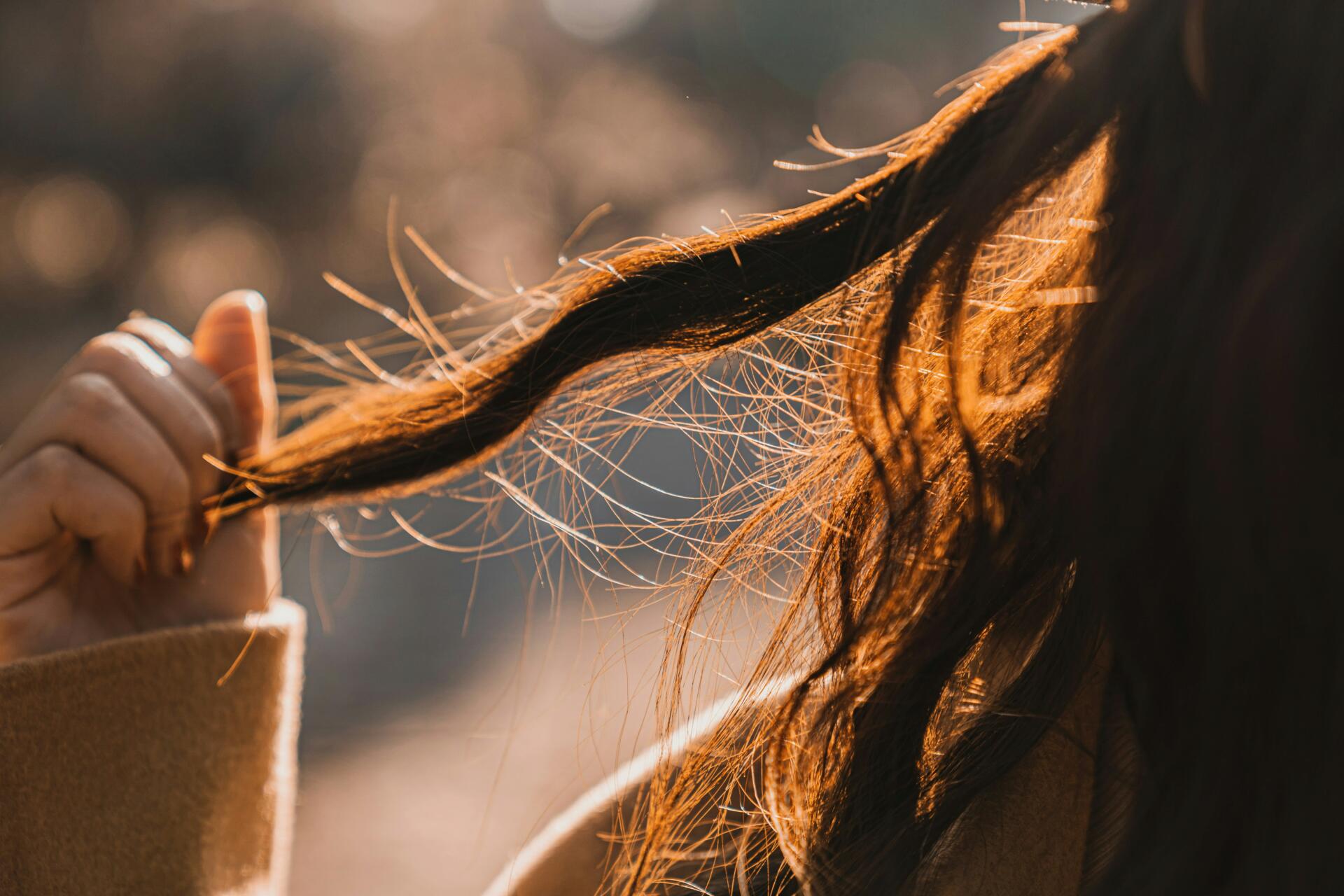 Young woman holding out locks of hair