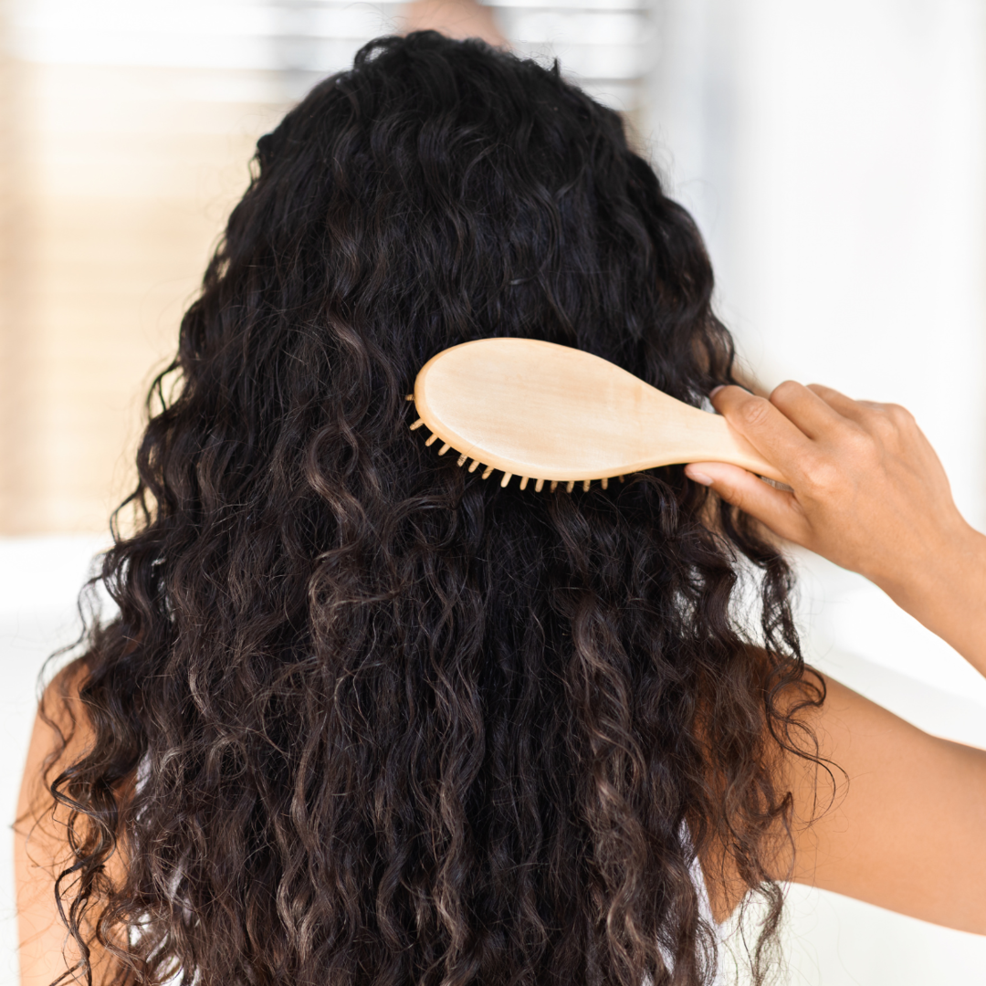 Woman brushing curly hair